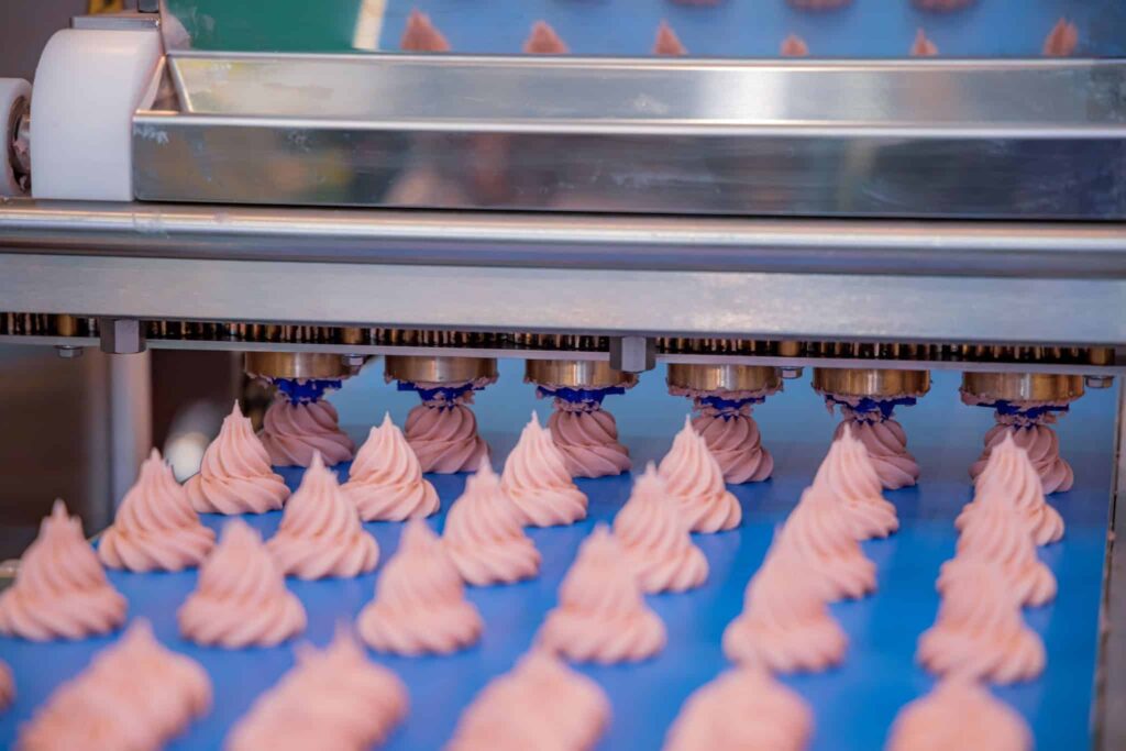 Cakes on an automatic conveyor belt system during the process of baking