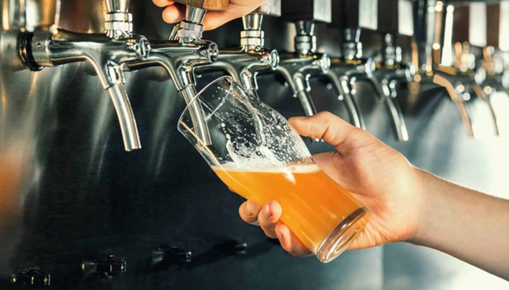 Eine Person gießt Bier in ein Glas