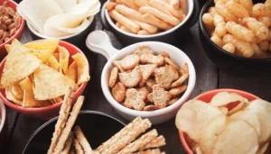 Different kinds of snack foods in bowls on the table 