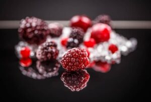 Frozen raspberries on a black surface