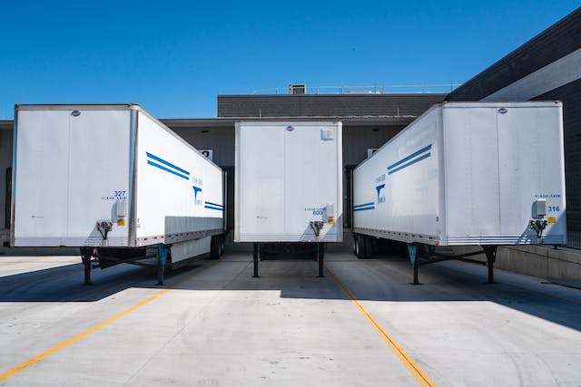 Three white enclosed trailers