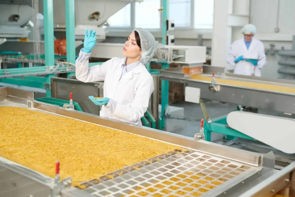 A woman examining products in front of a conveyor belt system