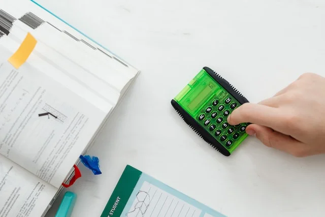 Une personne utilisant une calculatrice verte